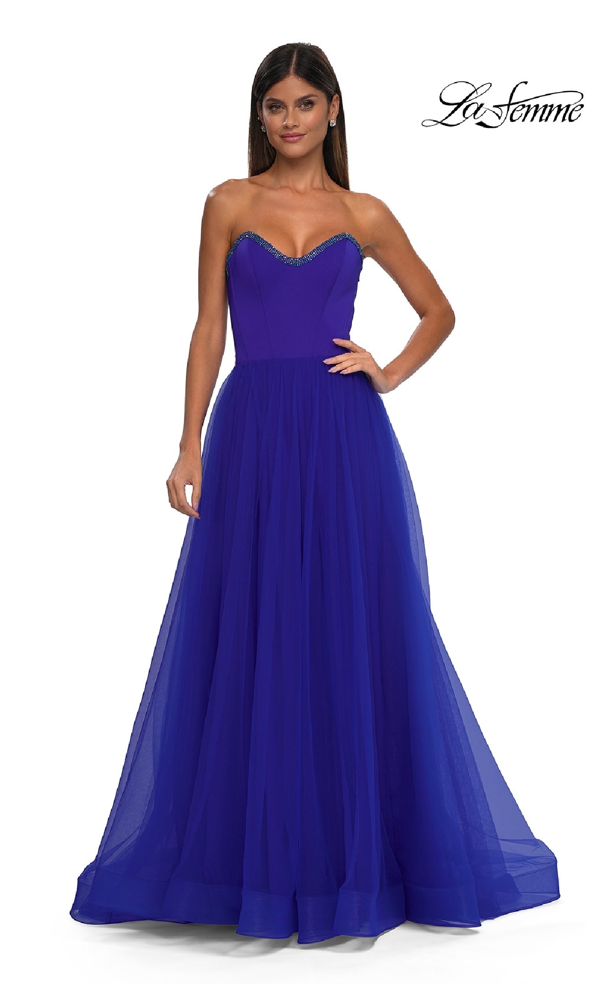 A woman stands against a white background wearing the Strapless Long Prom Ball Gown: La Femme 32731—a royal blue, floor-length ball gown featuring a fitted bodice and full tulle skirt.